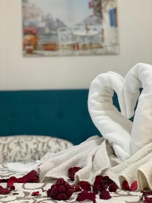 a bed with a white towel and flowers on it at Apartments Pericic in Sutomore