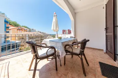 a table and chairs on a balcony with a view at Olive Garden Apartments in Sveti Stefan