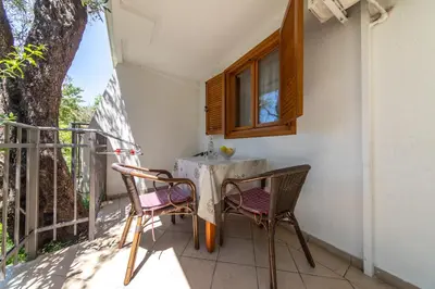 a table and chairs on the balcony of a house at Olive Garden Apartments in Sveti Stefan