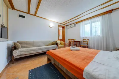 a hotel room with a bed and a couch at Olive Garden Apartments in Sveti Stefan