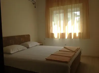 a bed in a room with a window with towels on it at Apartments Kordic in Budva