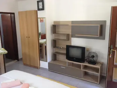 a living room with a tv on a shelf at Apartments Kordic in Budva