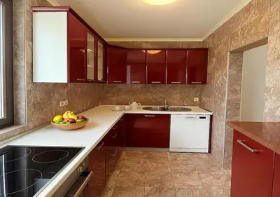 a kitchen with red cabinets and a bowl of fruit on the counter at Apartments Villa Mirjana in Budva