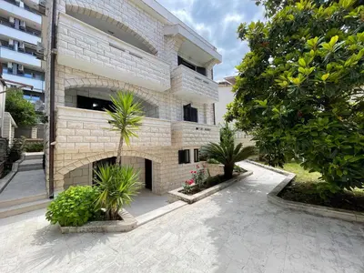 a building with a courtyard with trees and plants at Apartments Villa Mirjana in Budva