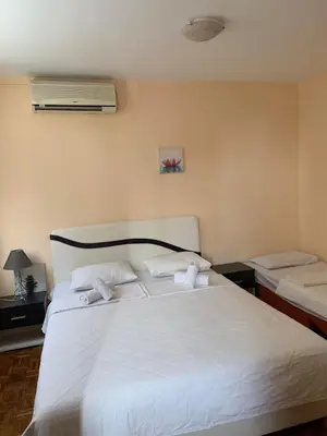a bedroom with a large bed with white sheets at Apartments Dunja in Sveti Stefan