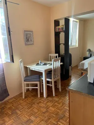 a dining room with a table and chairs and a bed at Apartments Dunja in Sveti Stefan