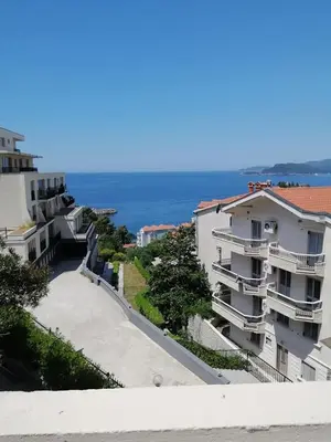 a view of some buildings with the ocean in the background at Apartments Dunja in Sveti Stefan