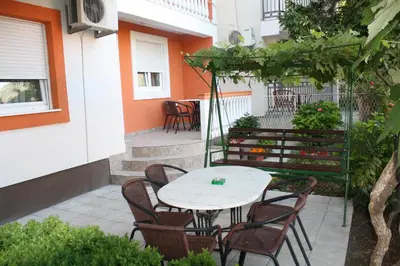 a patio with a table and chairs in a courtyard at Apartments Brnjada in Sutomore