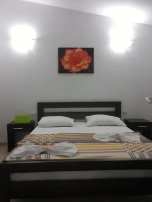 a bedroom with a bed with a painting on the wall at Apartments Brnjada in Sutomore
