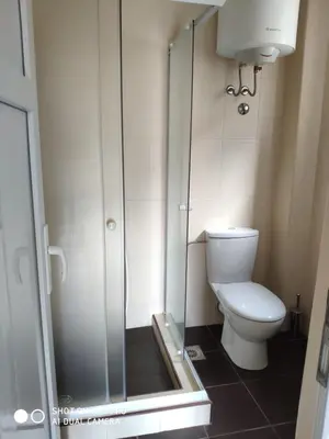 a bathroom with a toilet and a glass shower at Apartments Brnjada in Sutomore