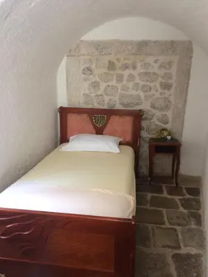 a bed in a room with a stone wall at Apartment Ozana in Kotor
