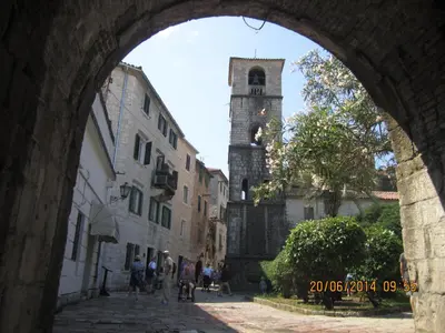 a group of people walking down a street with a clock tower at Apartment Ozana in Kotor