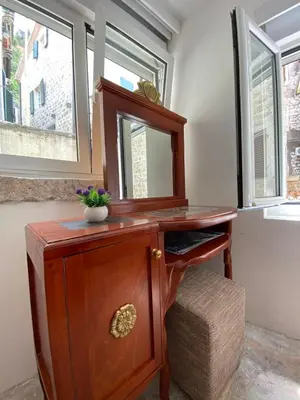 a wooden dresser with a mirror on top of it at Apartment Ozana in Kotor