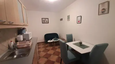 a kitchen with a sink and a table with chairs at Apartment Ozana in Kotor
