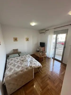a bedroom with a bed and a wooden floor at Stex Urban 4 in Podgorica