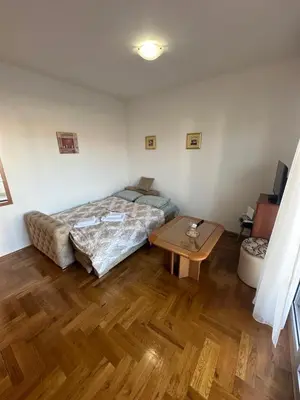 a bedroom with a bed and a table in it at Stex Urban 4 in Podgorica