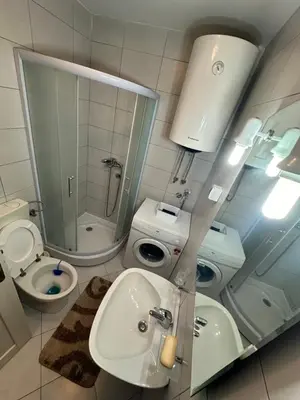 a bathroom with a sink and a toilet and a mirror at Stex Urban 4 in Podgorica