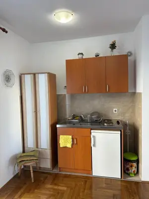 a kitchen with wooden cabinets and a white refrigerator at Stex Urban 4 in Podgorica