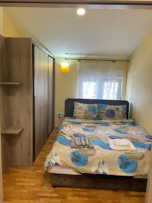 a bedroom with a bed with a blue and white comforter at Prestige 3 in Podgorica