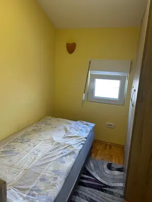 a small bedroom with a bed and a window at Prestige 3 in Podgorica