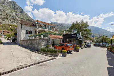 an orange car parked in front of a building on a street at Apartment Mrsulja in Kotor