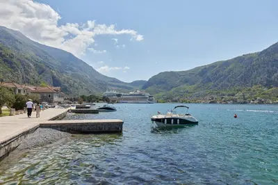 a boat in the water next to a dock at Apartment Mrsulja in Kotor