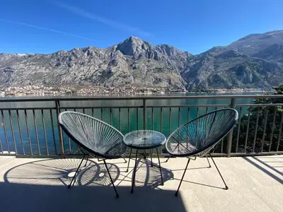 two chairs and a table on a balcony overlooking the water at Seafront Apartments House 44 Private Balcony Old Town View in Kotor