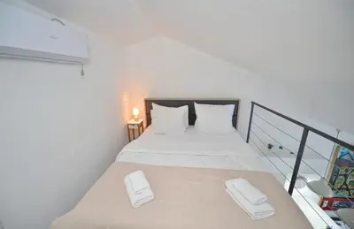 a bedroom with a bed with white pillows on it at Seafront Apartments House 44 Private Balcony Old Town View in Kotor