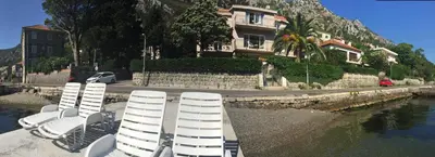 a group of chairs sitting on a dock in the water at Seafront Apartments House 44 Private Balcony Old Town View in Kotor