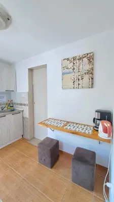 a kitchen with a table and two stools at Apartments Škaljari in Kotor