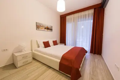 a bedroom with a large bed and a window at Apart Hotel Sea Fort in Sutomore