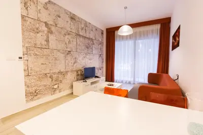 a room with a bed and a chair and a television at Apart Hotel Sea Fort in Sutomore