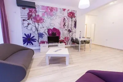 a living room with a couch and a tv at Apart Hotel Sea Fort in Sutomore
