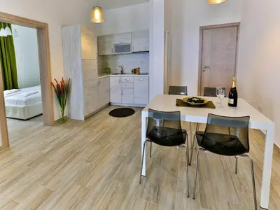 a kitchen with a table and chairs in a room at Apart Hotel Sea Fort in Sutomore
