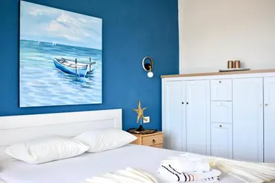 a bedroom with a bed with a painting of a boat at Guesthouse HHL - Liman ll in Ulcinj