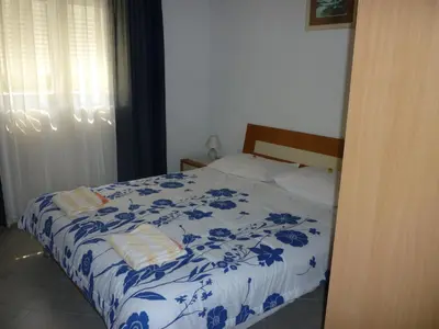 a blue and white bed with two towels on it at Apartments Dijana in Budva