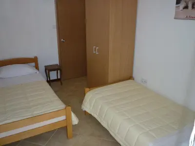 a bedroom with two beds and a cabinet at Apartments Dijana in Budva