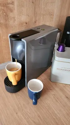 a coffee maker with a cup of coffee and two cups at Marelis condo with sea view in Ulcinj