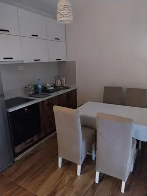a kitchen with a table and two chairs and a counter at Obilex in Podgorica