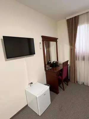 a hotel room with a desk and a flat screen tv at Zeta Lux in Mitrovići