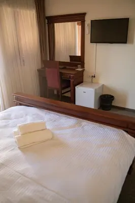 a bedroom with a bed with a desk and a television at Zeta Lux in Mitrovići