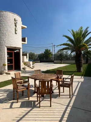 a wooden table and chairs and a table and a palm tree at Zeta Lux in Mitrovići