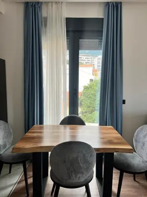 a dining room table with chairs and a window at Kabaseo Spa in Becici