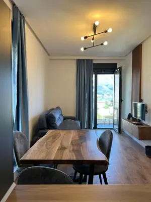 a living room with a wooden table and chairs at Kabaseo Spa in Becici