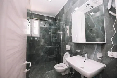 a bathroom with a sink and a toilet and a mirror at Apartments Art in Ulcinj