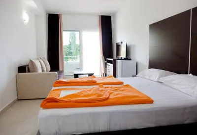 a bedroom with two beds with an orange blanket at Apartments Art in Ulcinj