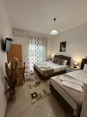 a large room with two beds and a tv at Apartments Sija in Ulcinj