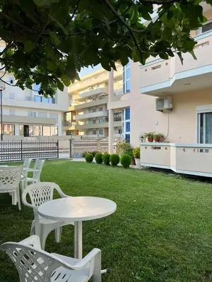 a table and chairs on a lawn in front of a building at Apartments Sija in Ulcinj