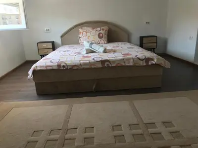 a bedroom with a bed with a blanket and a rug at Apartments OldTown in Podgorica
