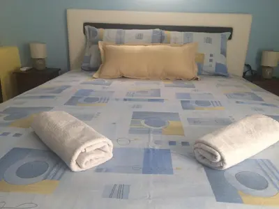 a blue and yellow bed with towels on it at Apartments OldTown in Podgorica